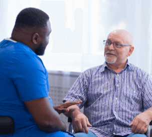 nurse and elderly man talking